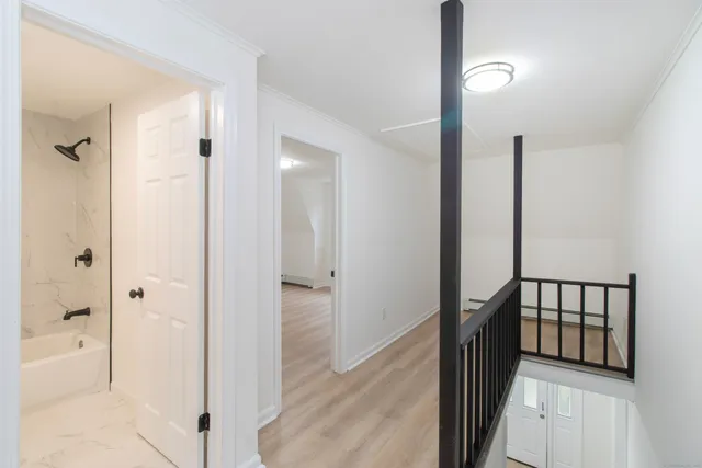 a view of a hallway with a door and chair