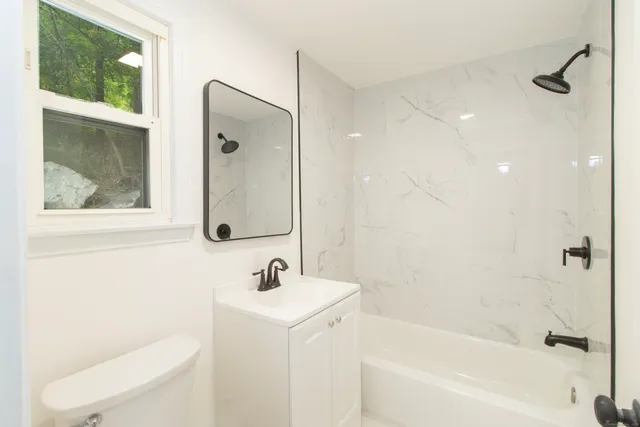 a bathroom with a sink a toilet and shower