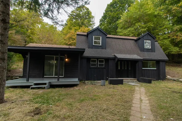 a view of a house with backyard and trees