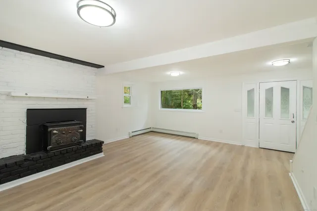 an empty room with windows and fireplace