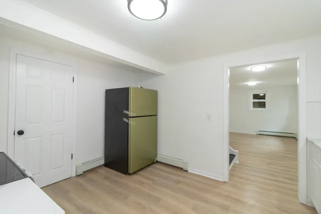 a view of a room with wooden floor and a sink