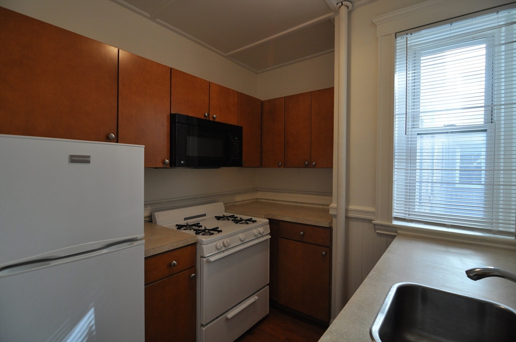 131 Park Drive, Unit 11 Boston, MA 02215 - Photo 4 of 15 a kitchen with stainless steel appliances a stove a microwave and a refrigerator