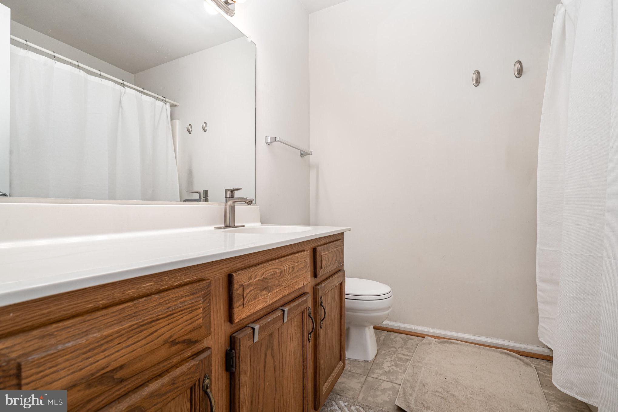205 Powhatan Court, Unit 100 Stafford, VA 22556 - Photo 16 of 23 a bathroom with a sink a toilet and shower