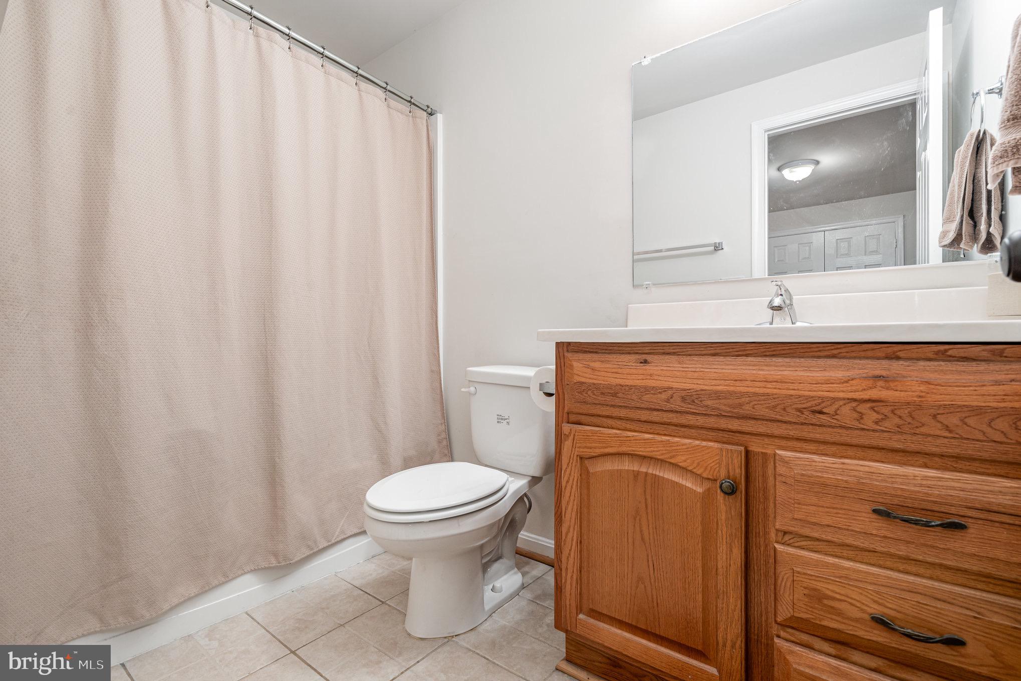 205 Powhatan Court, Unit 100 Stafford, VA 22556 - Photo 21 of 23 a bathroom with a sink a toilet and a mirror