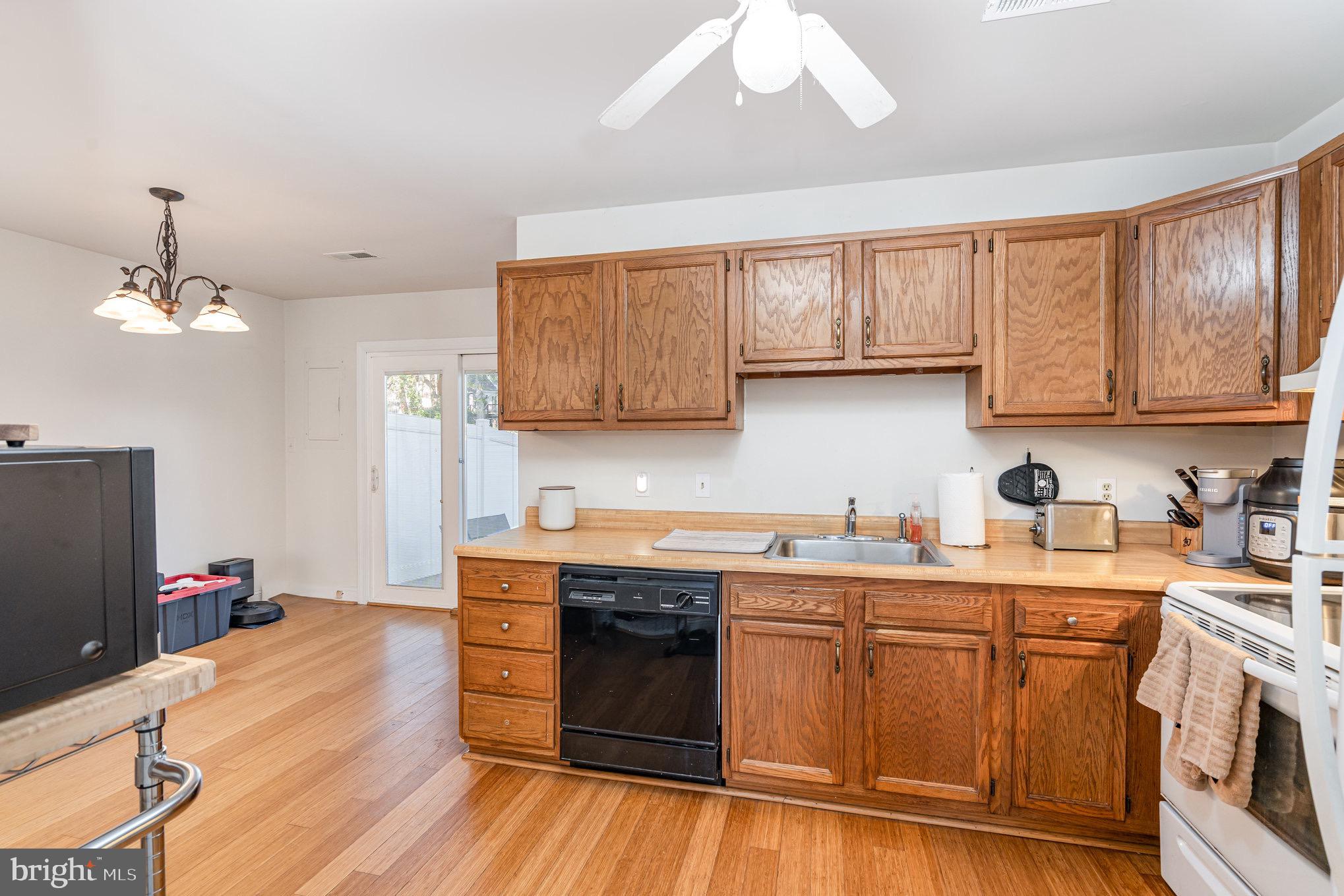 205 Powhatan Court, Unit 100 Stafford, VA 22556 - Photo 6 of 23 a kitchen with stainless steel appliances granite countertop a sink stove and wooden cabinets