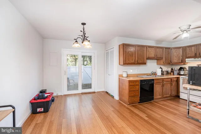 a kitchen with granite countertop a stove a sink dishwasher and a refrigerator with wooden floor