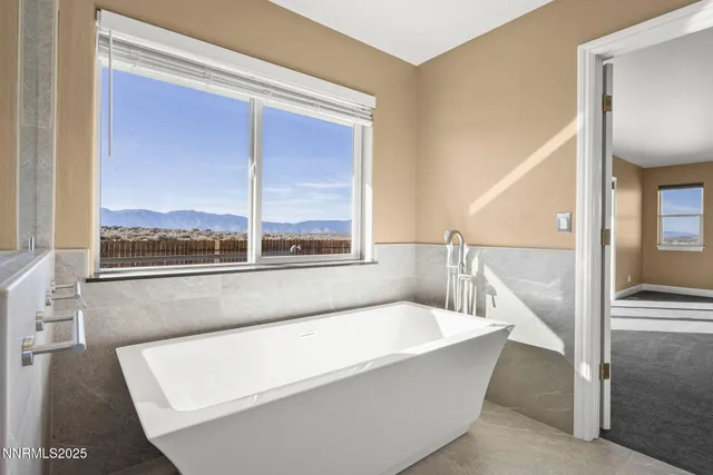 a bathroom with a bathtub and next to a window
