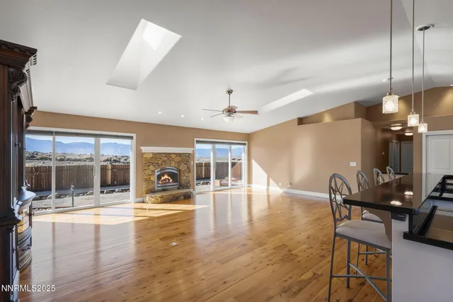 a view of a livingroom with furniture wooden floor a fireplace and windows