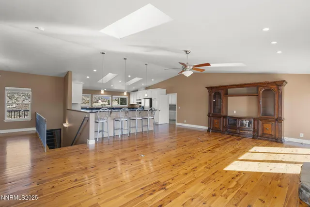 a room with lots of dining table furniture and view of kitchen