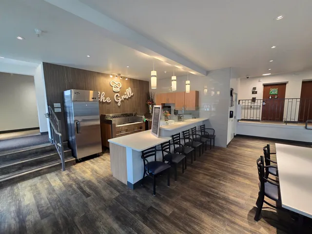 a large kitchen with stainless steel appliances lots of counter space and furniture