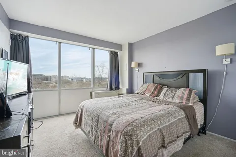 a bedroom with a large bed and a large window