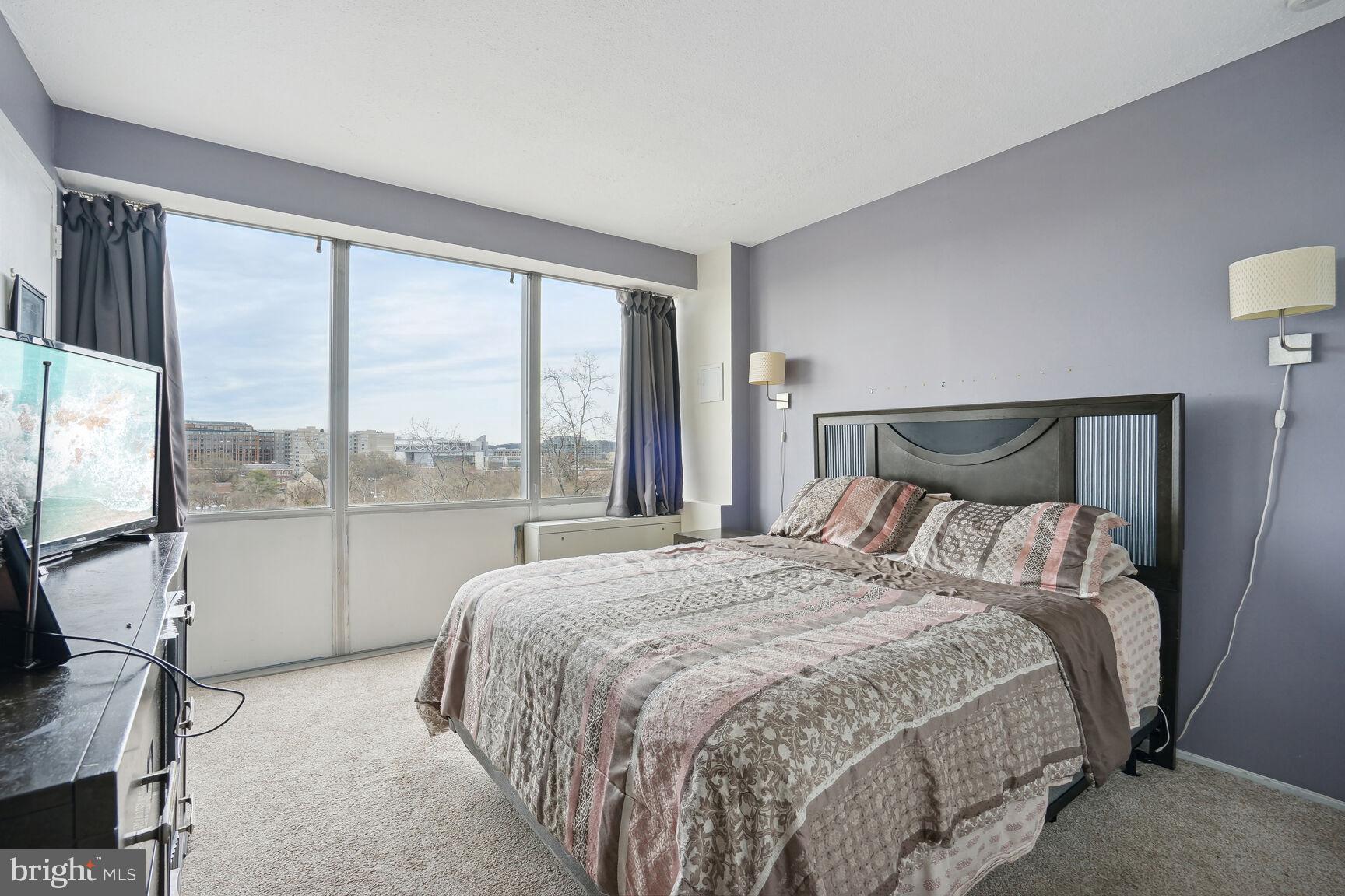 1301 Delaware Avenue Southwest, Unit N816 Washington, DC 20024 - Photo 8 of 16 a bedroom with a large bed and a large window