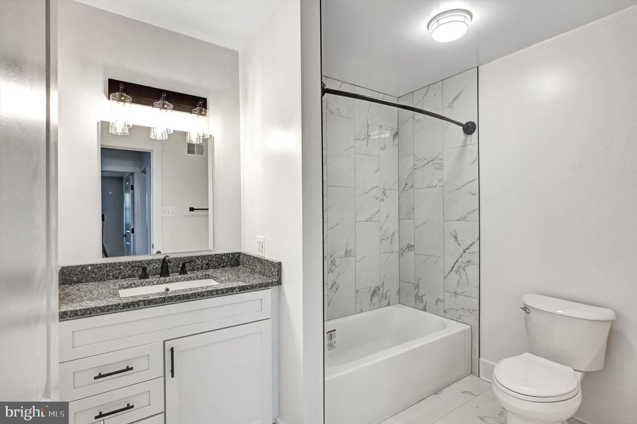 2806 Foxhound Road Ellicott City, MD 21042 - Photo 24 of 55 a bathroom with a granite countertop sink a toilet and shower
