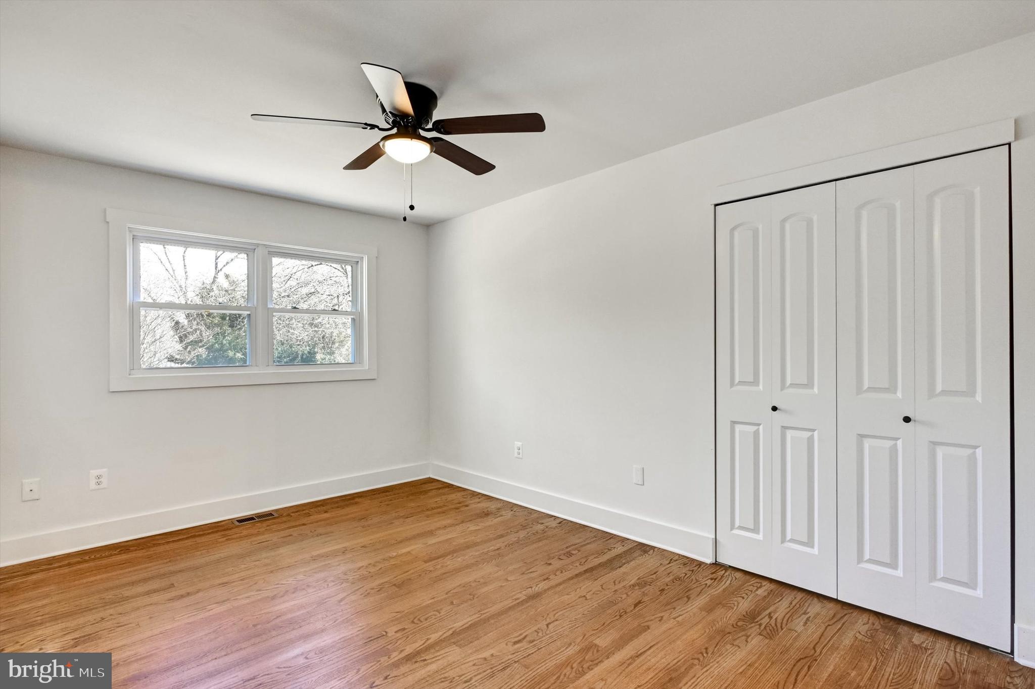 2806 Foxhound Road Ellicott City, MD 21042 - Photo 26 of 55 an empty room with wooden floor chandelier fan and windows