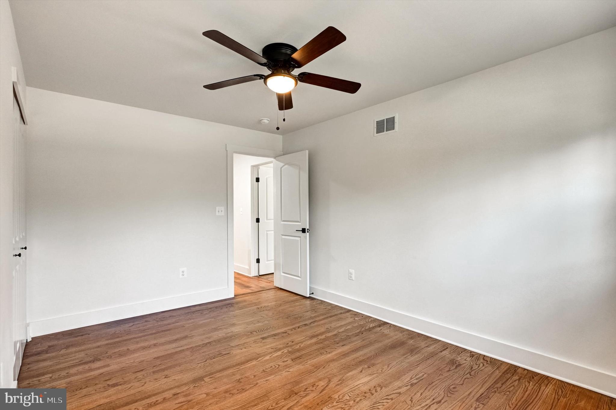 2806 Foxhound Road Ellicott City, MD 21042 - Photo 27 of 55 an empty room with wooden floor and ceiling fan