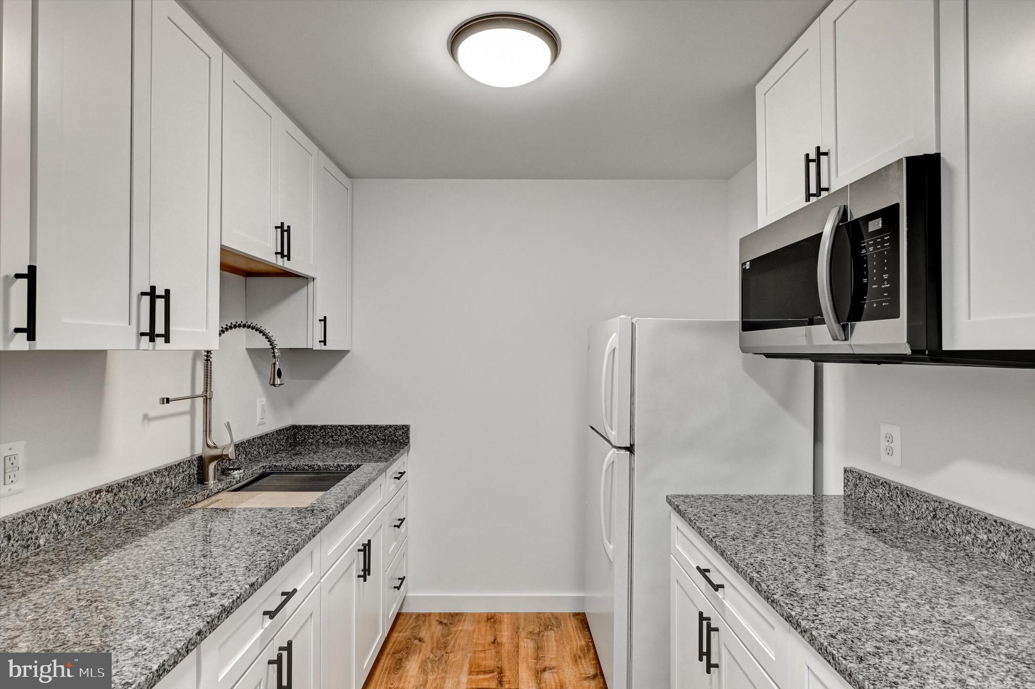 2806 Foxhound Road Ellicott City, MD 21042 - Photo 29 of 55 a kitchen with stainless steel appliances granite countertop a sink stove and refrigerator