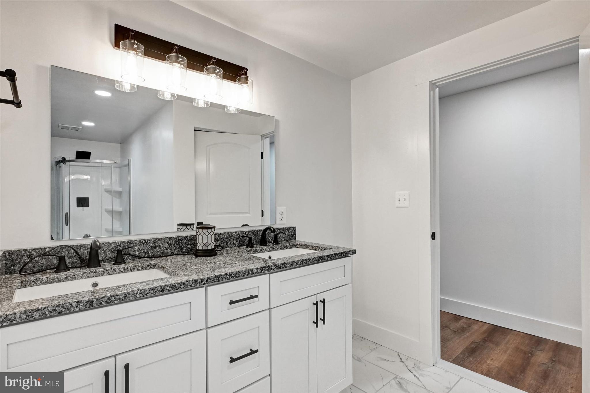 2806 Foxhound Road Ellicott City, MD 21042 - Photo 31 of 55 a bathroom with a granite countertop sink and a mirror