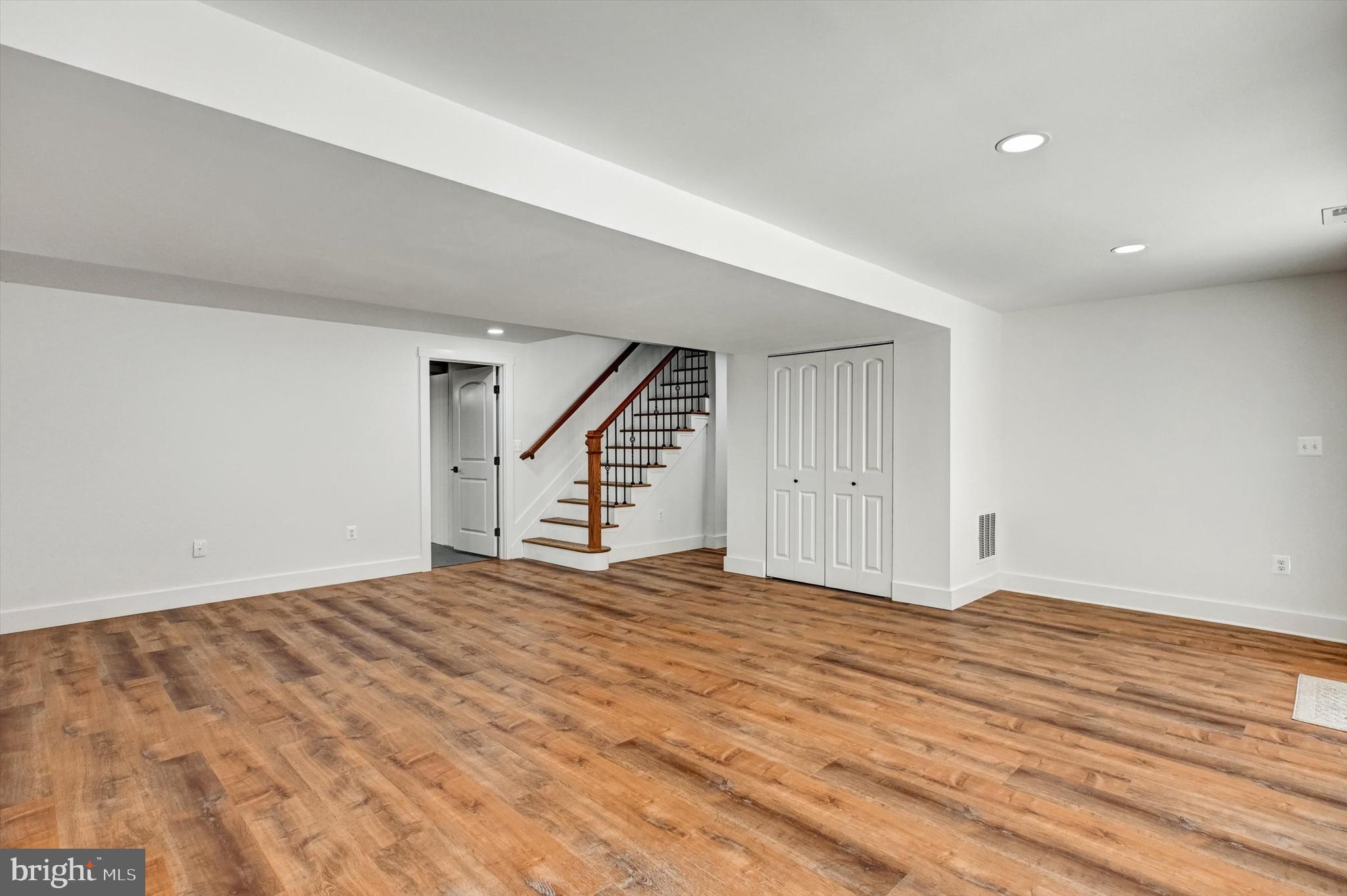 2806 Foxhound Road Ellicott City, MD 21042 - Photo 35 of 55 a view of an empty room with wooden floor and stairs