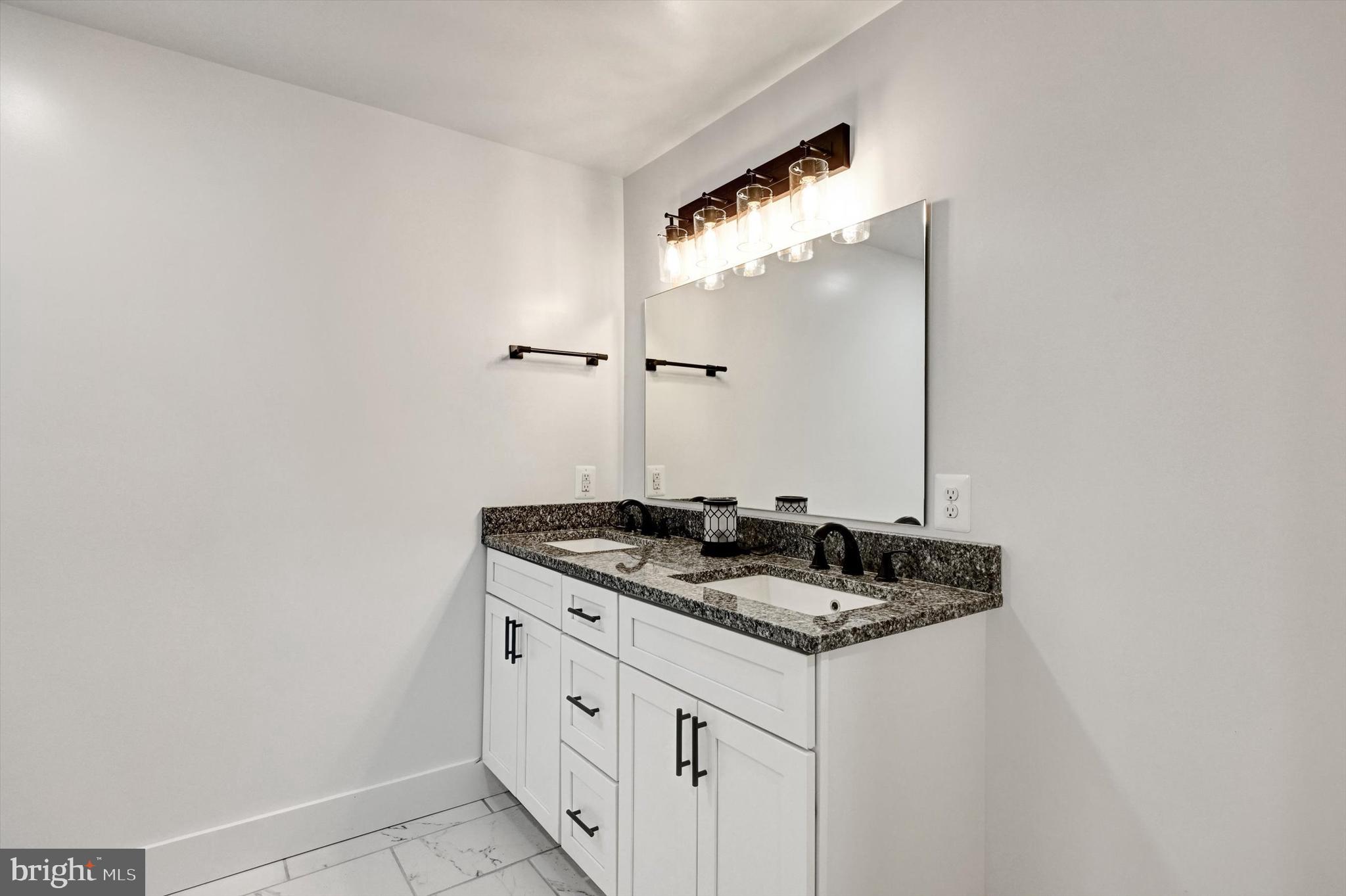 2806 Foxhound Road Ellicott City, MD 21042 - Photo 39 of 55 a bathroom with a granite countertop sink and a mirror
