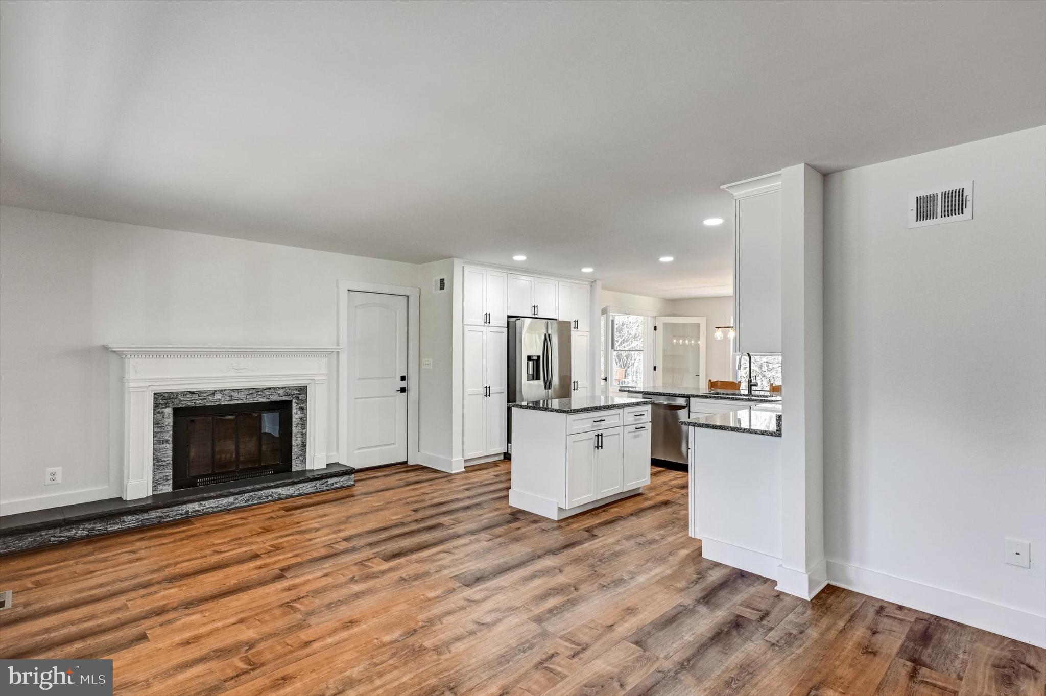 2806 Foxhound Road Ellicott City, MD 21042 - Photo 4 of 55 a view of kitchen with wooden floor and a fireplace