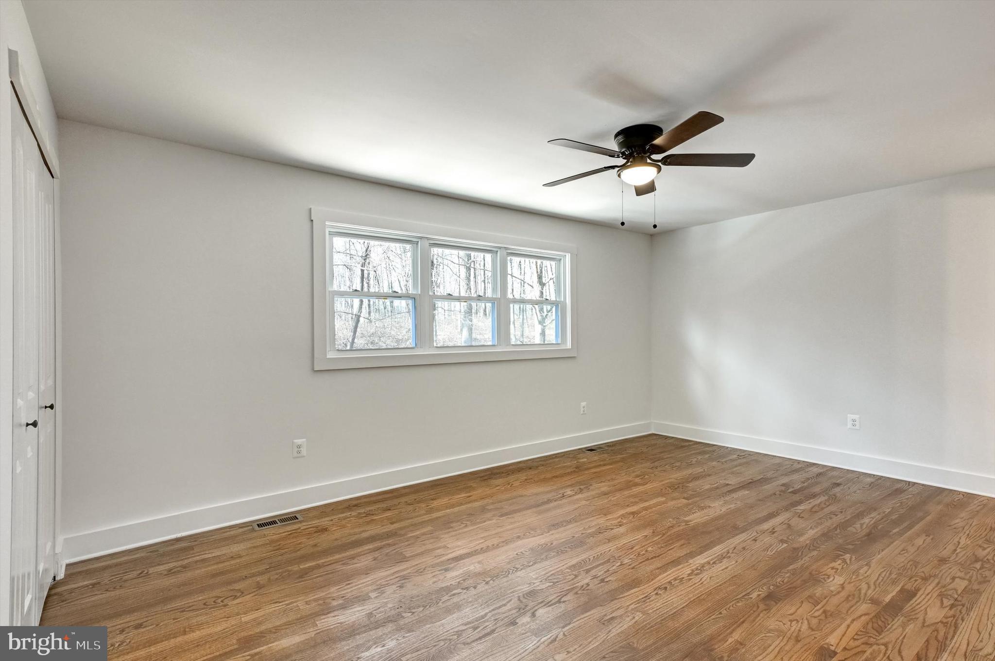 2806 Foxhound Road Ellicott City, MD 21042 - Photo 45 of 55 a view of a room with wooden floor ceiling fan and windows