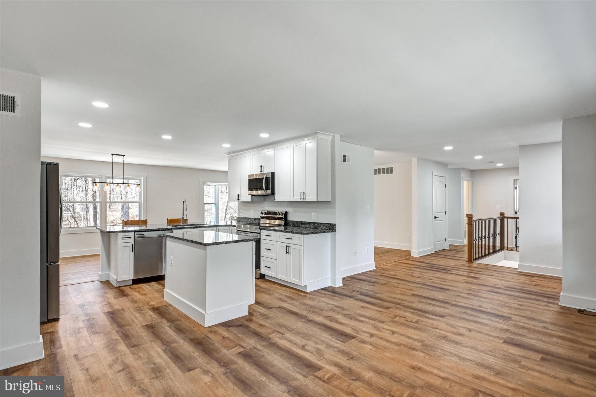 2806 Foxhound Road Ellicott City, MD 21042 - Photo 7 of 55 a open kitchen with a refrigerator a sink dishwasher with a dining table and chairs