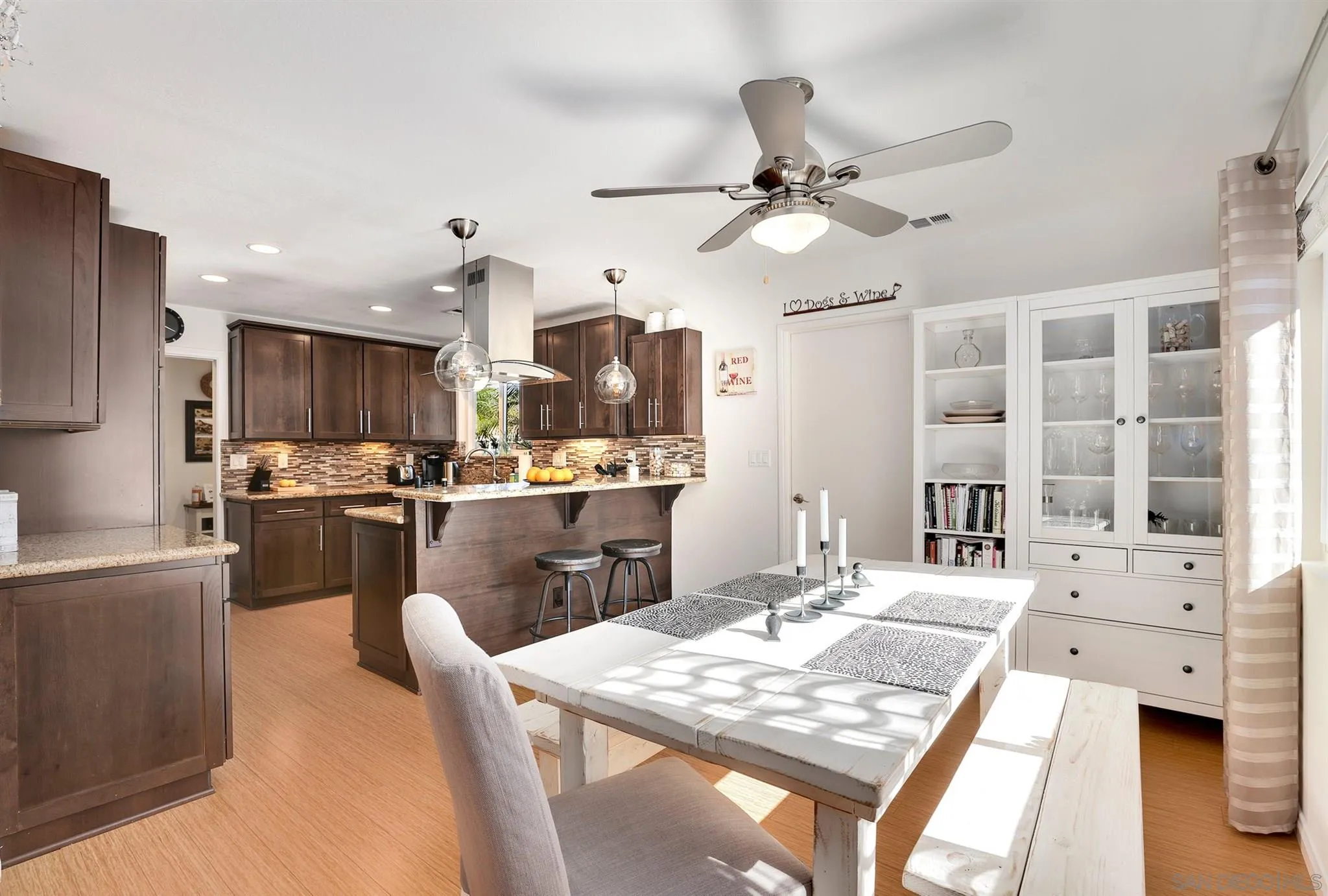 13716 Frame Road Poway, CA 92064 - Photo 13 of 34 a kitchen with stainless steel appliances kitchen island granite countertop a refrigerator a stove top oven a sink dishwasher and white cabinets with wooden floor