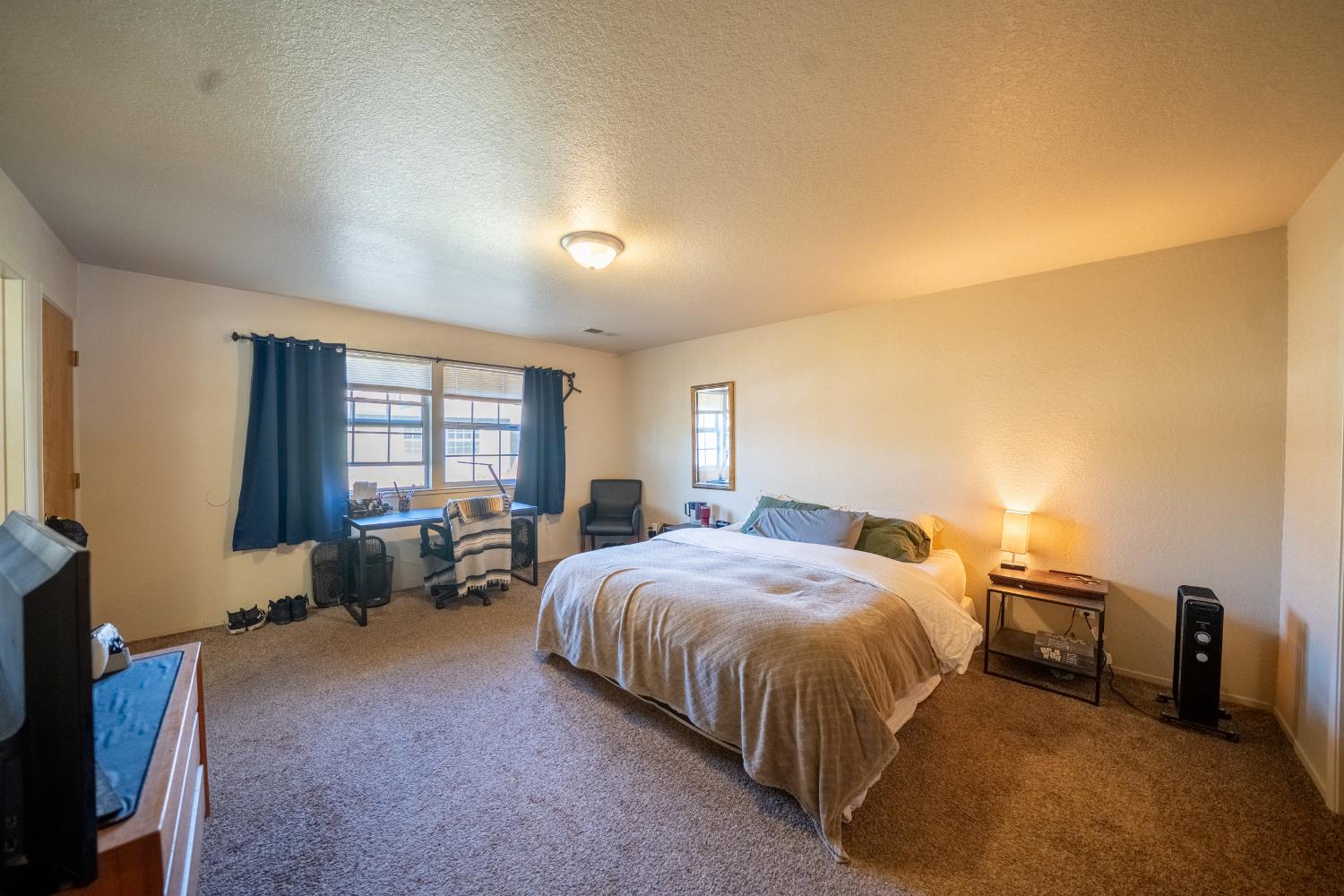494 Surrey Court Murphys, CA 95247 - Photo 57 of 76 a spacious bedroom with a bed and a dresser next to a window