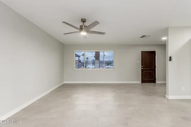 an empty room with a ceiling fan and a window