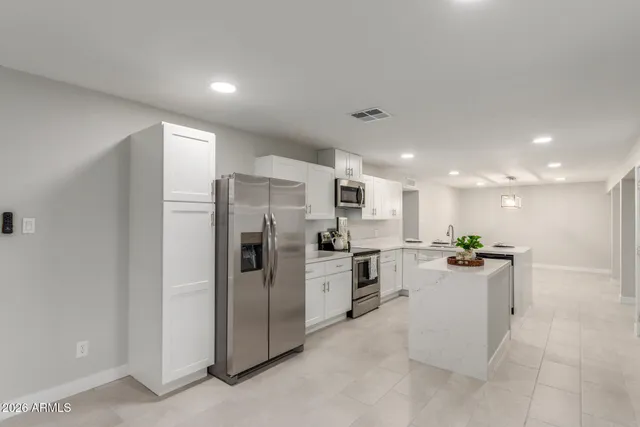a kitchen with refrigerator and cabinets