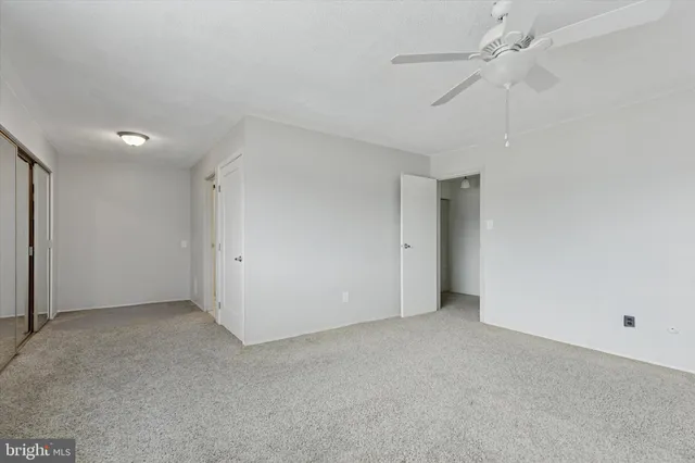 an empty room with a ceiling fan and a fan
