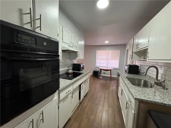 a kitchen with granite countertop a stove and cabinets