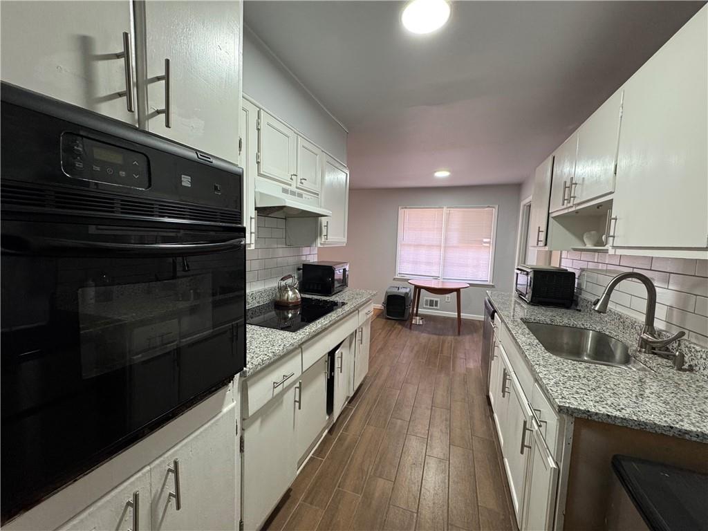 3080 Forrest Park Road Southeast Atlanta, GA 30354 - Photo 8 of 17 a kitchen with granite countertop a stove and cabinets