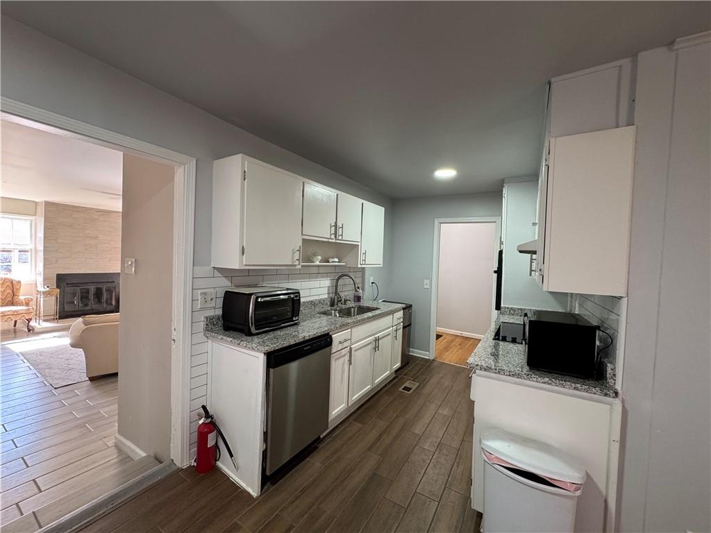 3080 Forrest Park Road Southeast Atlanta, GA 30354 - Photo 9 of 17 a kitchen with granite countertop a stove top oven a sink dishwasher and a refrigerator with wooden floor