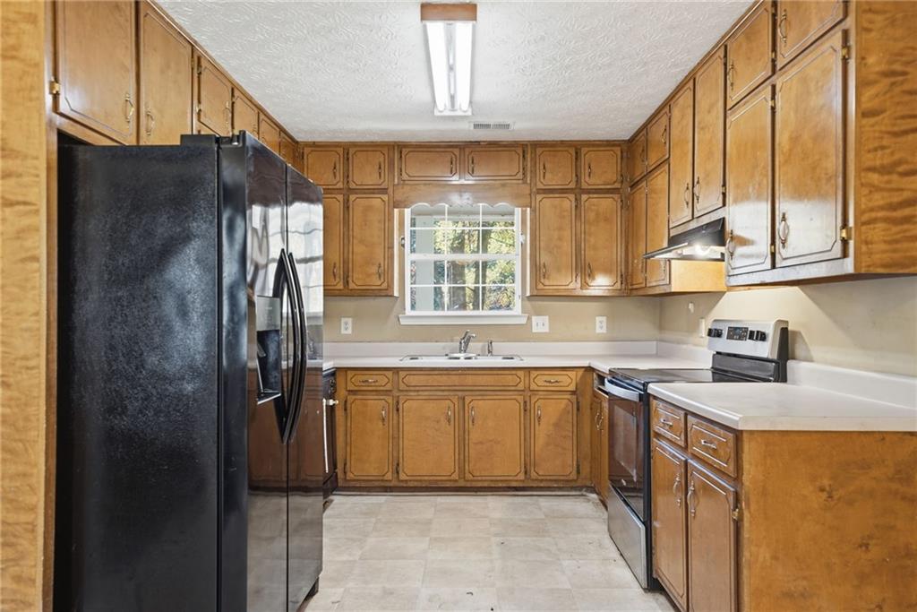 255 Countryside Lane Covington, GA 30016 - Photo 12 of 35 a kitchen with stainless steel appliances granite countertop a sink stove and refrigerator