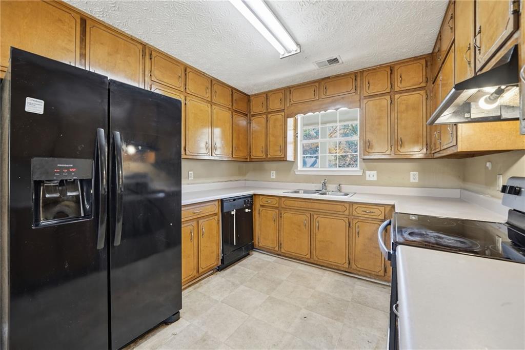 255 Countryside Lane Covington, GA 30016 - Photo 13 of 35 a kitchen with stainless steel appliances granite countertop a refrigerator and a sink