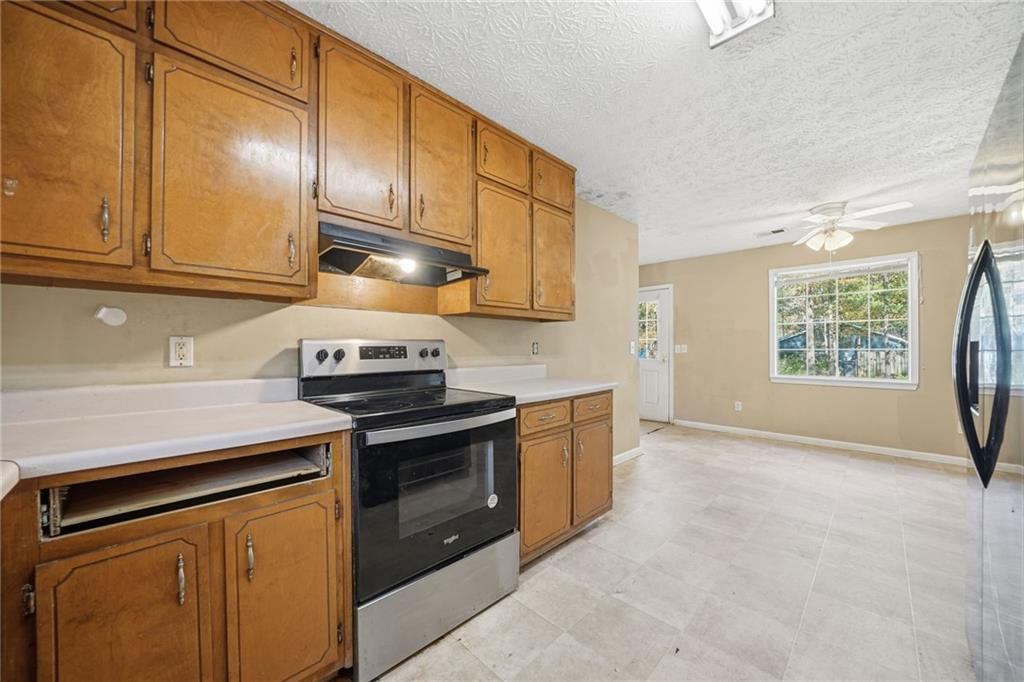 255 Countryside Lane Covington, GA 30016 - Photo 15 of 35 a kitchen with stainless steel appliances granite countertop a stove a sink and a microwave