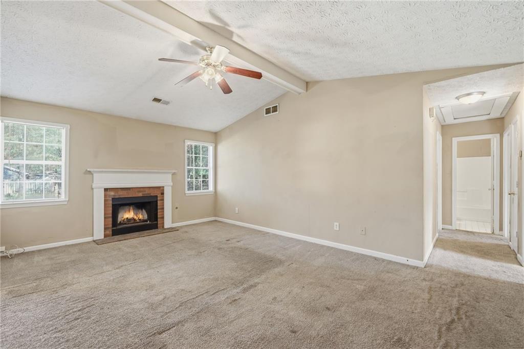 255 Countryside Lane Covington, GA 30016 - Photo 5 of 35 an empty room with windows and fireplace