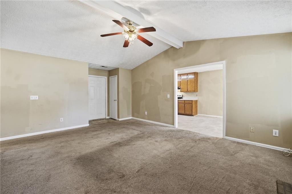 255 Countryside Lane Covington, GA 30016 - Photo 7 of 35 a view of an empty room with chandelier fan and windows