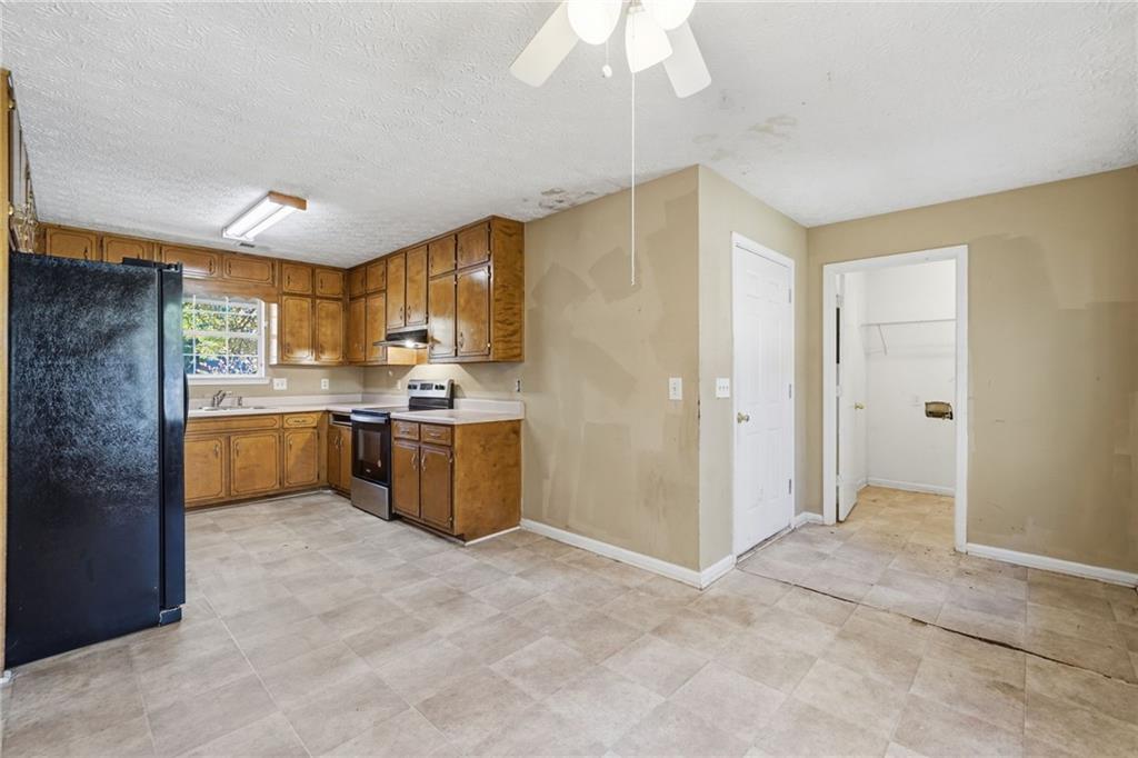 255 Countryside Lane Covington, GA 30016 - Photo 10 of 35 a kitchen with stainless steel appliances a sink a stove a refrigerator cabinets and a chandelier