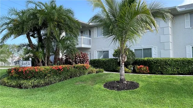 a front view of a house with a garden and plants
