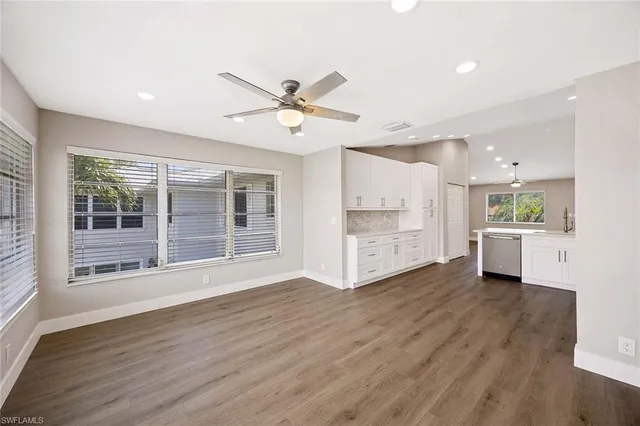 a view of a big room with wooden floor and a kitchen