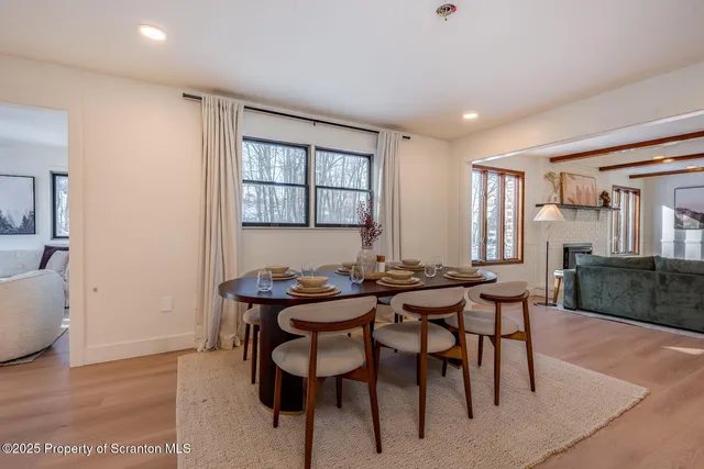 a kitchen with stainless steel appliances granite countertop a refrigerator a sink a stove top oven a kitchen island and chairs