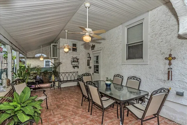a patio with table and chairs and potted plants