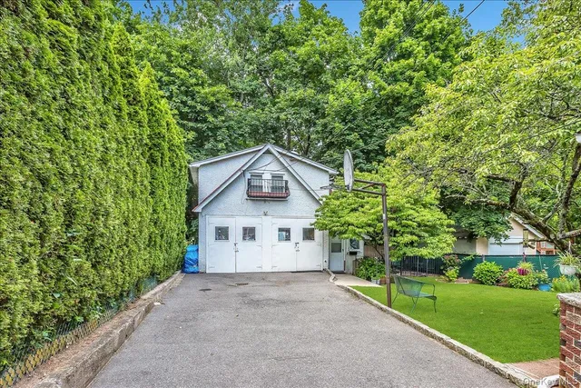 a view of a house with a yard and large tree