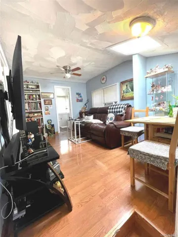 a kitchen with stainless steel appliances granite countertop a stove a refrigerator a sink dishwasher and white cabinets with wooden floor