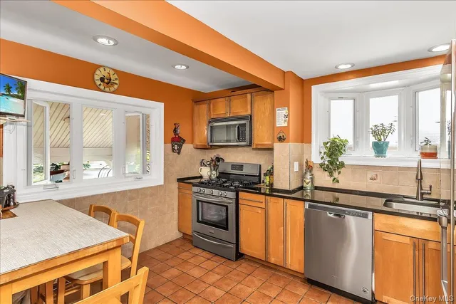 a kitchen with stainless steel appliances granite countertop a stove a sink and a microwave