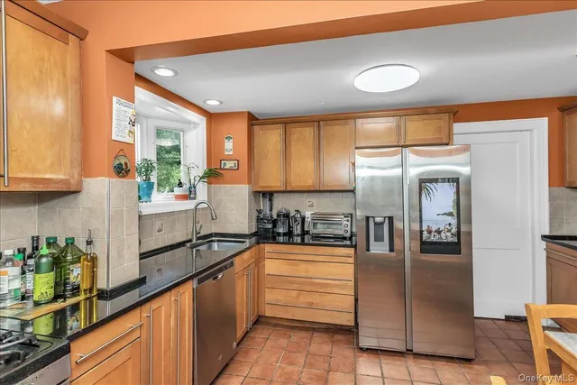 a large kitchen with granite countertop a sink and cabinets