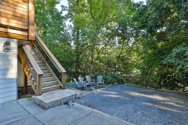 a kitchen with stainless steel appliances granite countertop a stove top oven a sink dishwasher and white cabinets with wooden floor