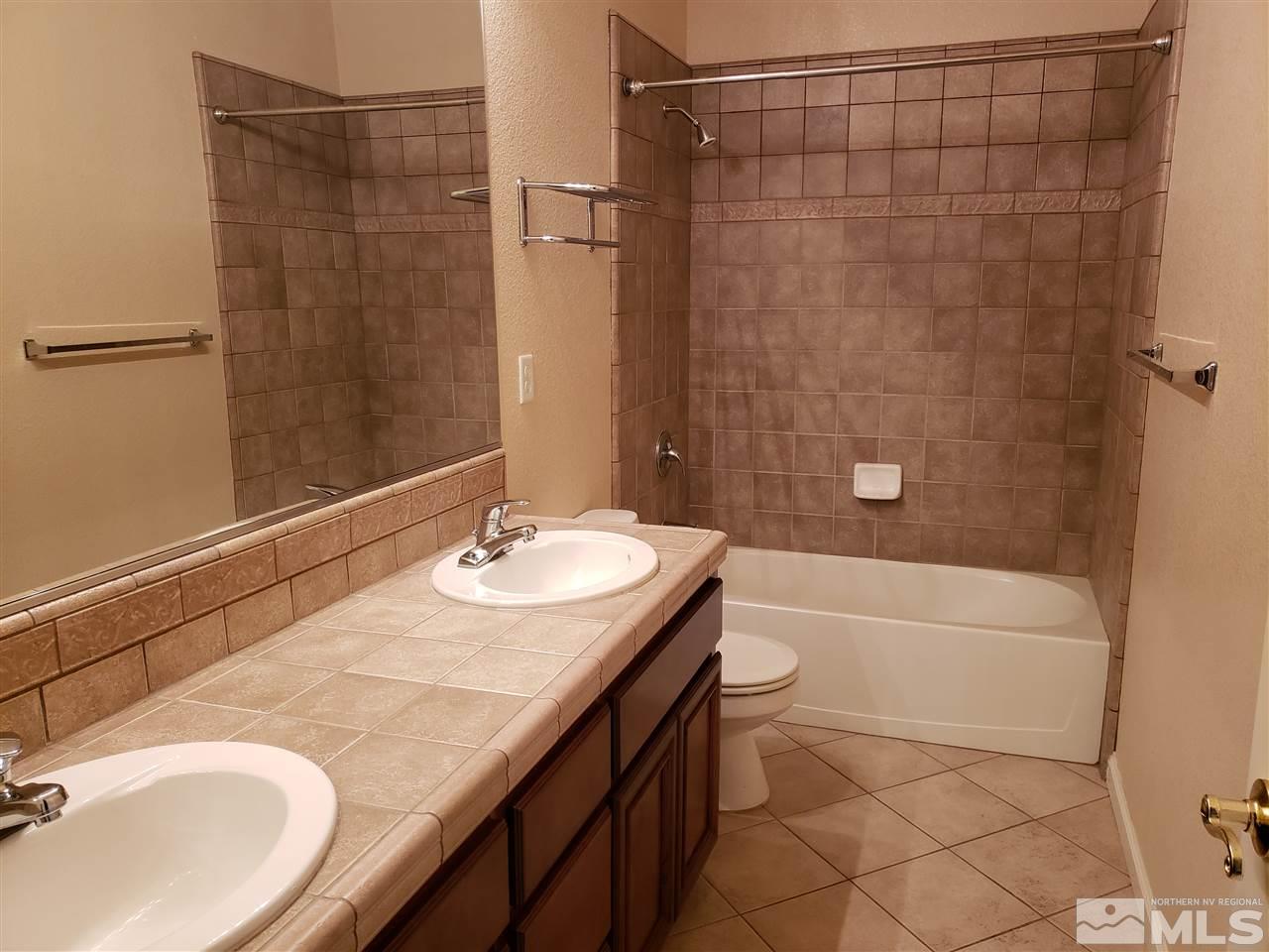 1680 Emerald Bay Drive Reno, NV 89521 - Photo 18 of 27 a bathroom with a granite countertop sink a toilet and shower